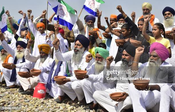 Agitating farmers holding demonstration by begging with earthen bowls during third day of 'rail roko' stir at the railway track at Village Devidas...