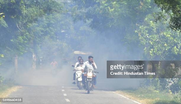 Commuters passing near field farmers burn stubble after harvesting a paddy crop in the field, on September 30, 2023 in Amritsar, India.
