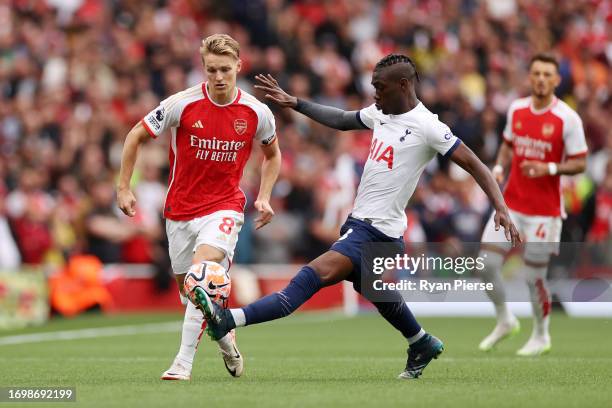 Martin Oedegaard of Arsenal battles for possession with Yves Bissouma of Tottenham Hotspur during the Premier League match between Arsenal FC and...