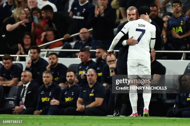 Tottenham Hotspur's Greek-Australian Head Coach Ange Postecoglou congratulates Tottenham Hotspur's South Korean striker Son Heung-Min as he leaves...