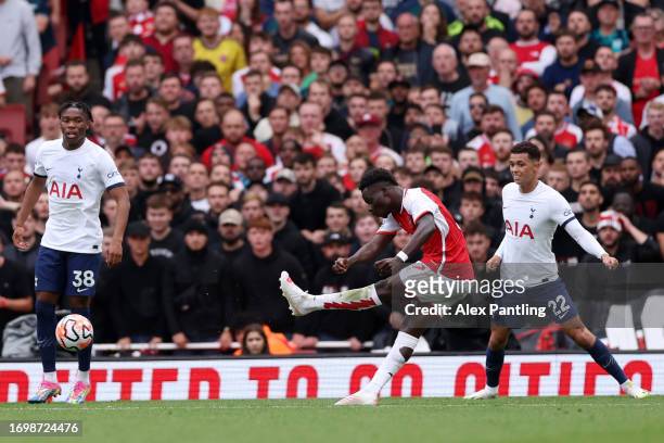 Bukayo Saka of Arsenal shoots before Cristian Romero of Tottenham Hotspur scores an own goal, Arsenal’s first goal during the Premier League match...
