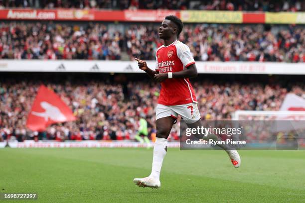 Bukayo Saka of Arsenal celebrates after an own goal by Cristian Romero of Tottenham Hotspur during the Premier League match between Arsenal FC and...