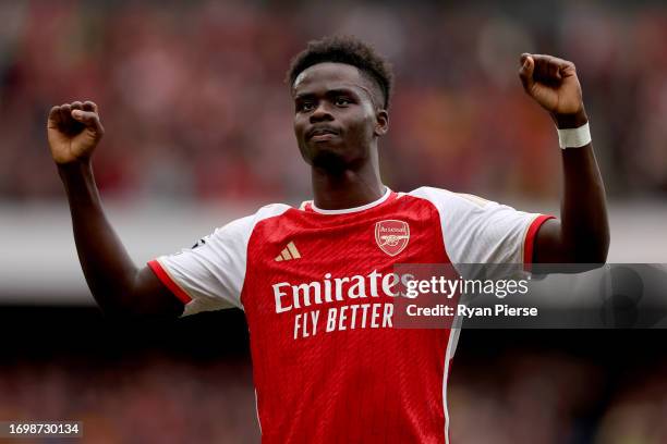 Bukayo Saka of Arsenal celebrates after an own goal by Cristian Romero of Tottenham Hotspur during the Premier League match between Arsenal FC and...