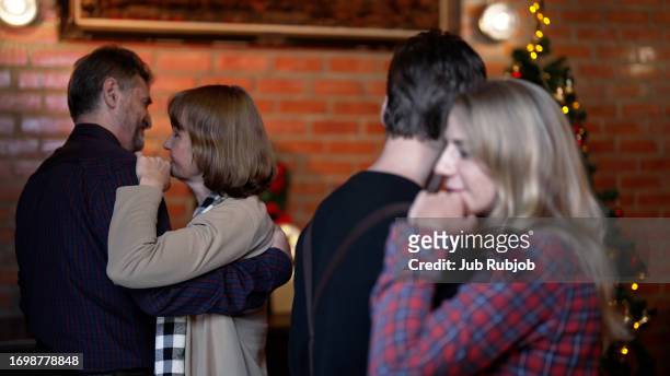 senior couple and young couple dancing together in the house decorating the house for christmas, smiling and cheerful family - fashionable grandma stock pictures, royalty-free photos & images