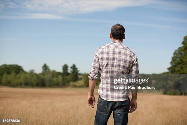 hombre de pie en un campo rural - de espalda fotografías e imágenes de stock