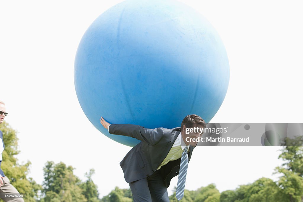 Empresário segurando Bola de grandes dimensões nas costas