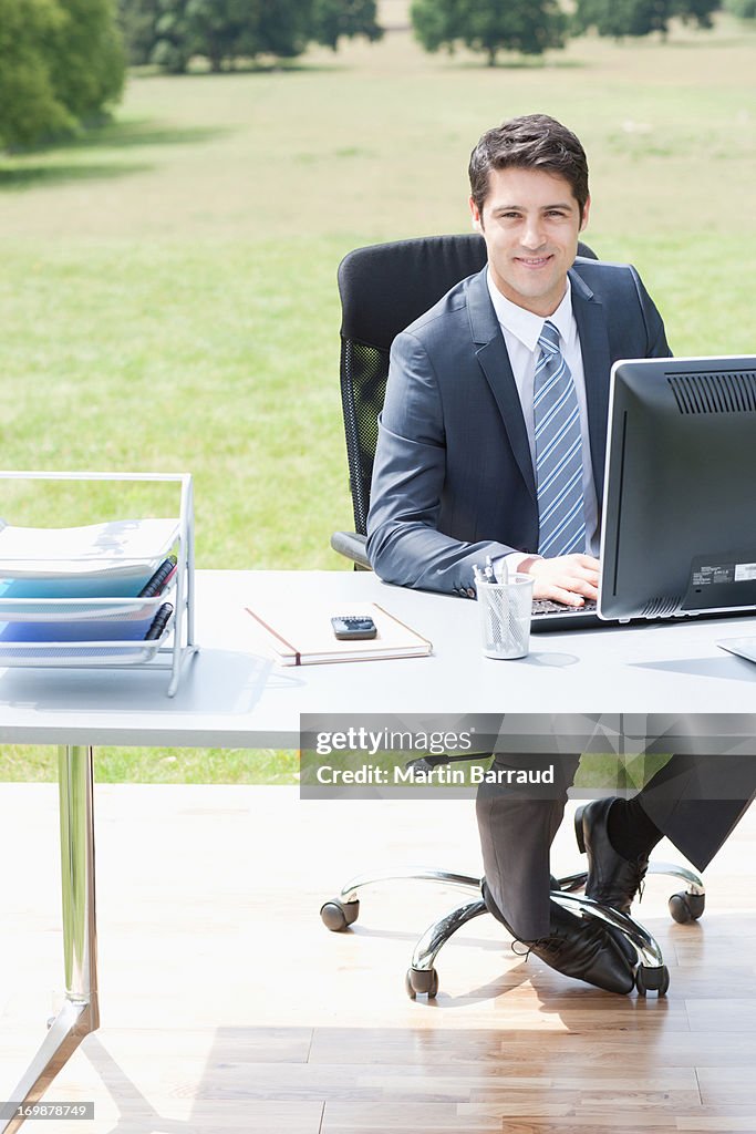 Businessman sitting at desk outdoors