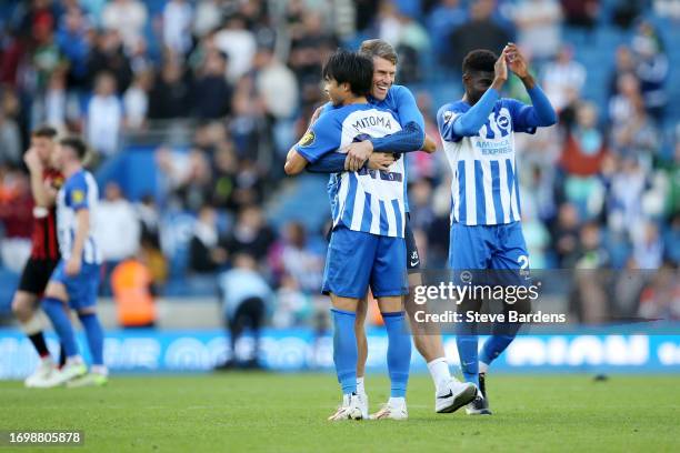 Kaoru Mitoma of Brighton & Hove Albion is embraced by Jack Stern, Goalkeeping Coach of Brighton & Hove Albion, after the team's victory in the...