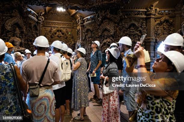 Tourists listen to a guided tour in the Russian language at the Sanctuary of Truth on September 24, 2023 in Pattaya, Thailand. Starting on September...