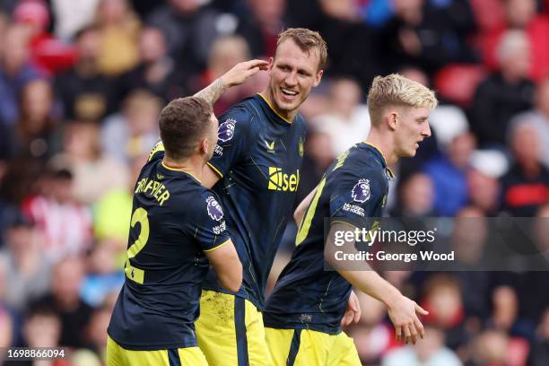 Dan Burn of Newcastle United celebrates with teammates after scoring the team's second goal during the Premier League match between Sheffield United...
