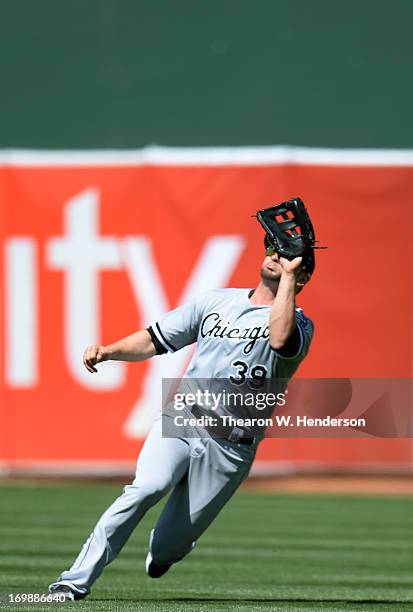 Right Fielder Casper Wells of the Chicago White Sox goes into a slide to catch a shallow fly ball taking a hit away from Chris Young of the Oakland...