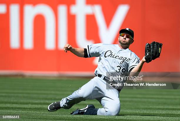 Right Fielder Casper Wells of the Chicago White Sox goes into a slide to catch a shallow fly ball taking a hit away from Chris Young of the Oakland...
