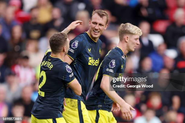 Dan Burn of Newcastle United celebrates with teammates after scoring the team's second goal during the Premier League match between Sheffield United...