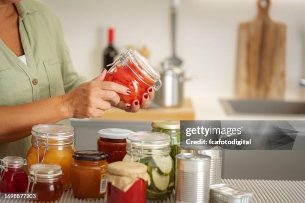 close up of woman,s hands holding a glass jar with preserved food - inlagd bildbanksfoton och bilder