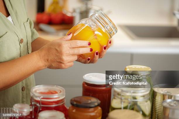 close up da mulher, s mãos segurando um frasco de vidro com alimentos conservados - preserved food - fotografias e filmes do acervo