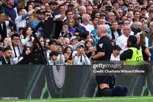 Referee Simon Hooper consults VAR during the Premier League match between Tottenham Hotspur and Liverpool FC at Tottenham Hotspur Stadium on...