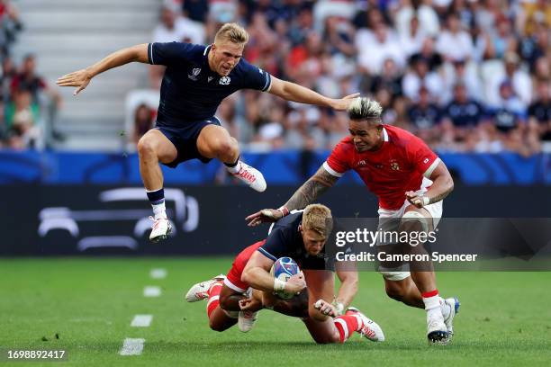 Kyle Steyn of Scotland is tackled by Pita Ahki and Vaea Fifita of Tonga during the Rugby World Cup France 2023 match between Scotland and Tonga at...