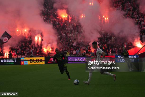 Supporters of Ajax cheer with smoke bombs during the Dutch Eredivisie match between AFC Ajax and Feyenoord at Johan Cruijff Arena on September 24,...