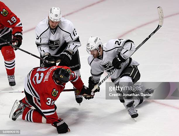 Kyle Clifford and Colin Fraser of the Los Angeles Kings rough up Michal Rozsival of the Chicago Blackhawks after Rozsival cross checked Fraser down...