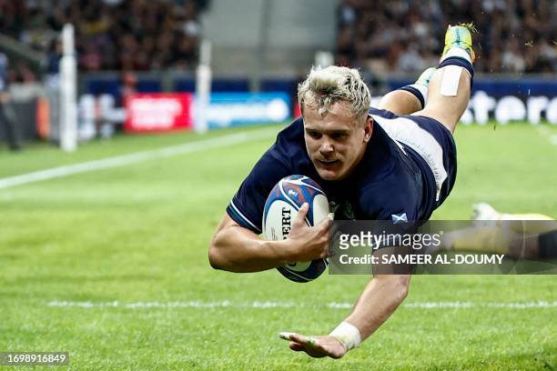 Scotland's wing Darcy Graham dives across the line to score a try during the France 2023 Rugby World Cup Pool B match between Scotland and Romania at...
