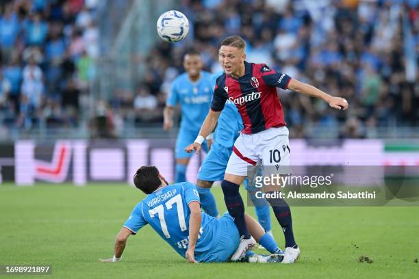 Jesper Karlsson of Bologna is challenged by Khvicha Kvaratskhelia of Napoli during the Serie A TIM match between Bologna FC and SSC Napoli at Stadio...