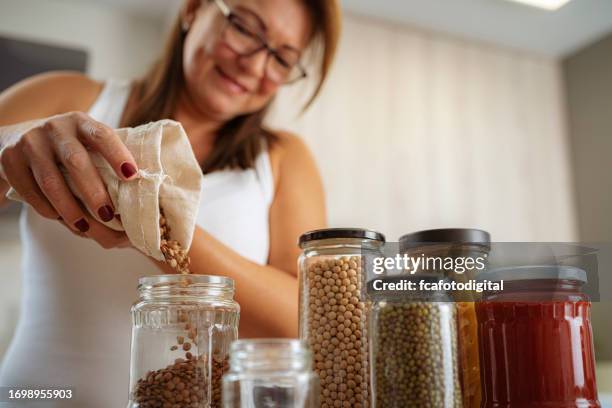 close up of a woman reusing glass jar to storage food - bean stock pictures, royalty-free photos & images