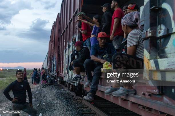 Migrant people, mostly from Venezuela, are seen after the goods train they were travelling on stopped for over 12 hours, in the Chihuahuan desert in...