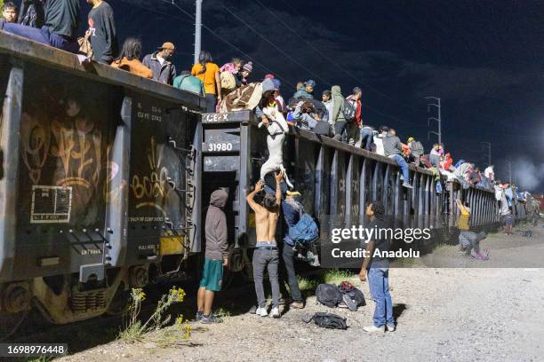 Migrant people, mostly from Venezuela, are seen after the goods train they were travelling on stopped for over 12 hours, in the Chihuahuan desert in...