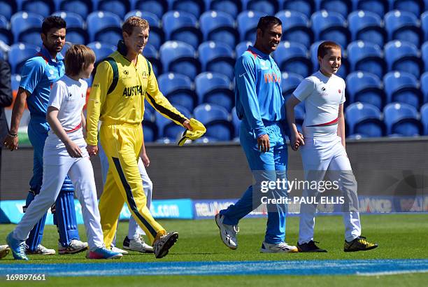 Australia's captain Michael Clarke and India's captain Mahendra Singh Dhoni walk onto the pitch for the warm-up cricket match ahead of the 2013 ICC...