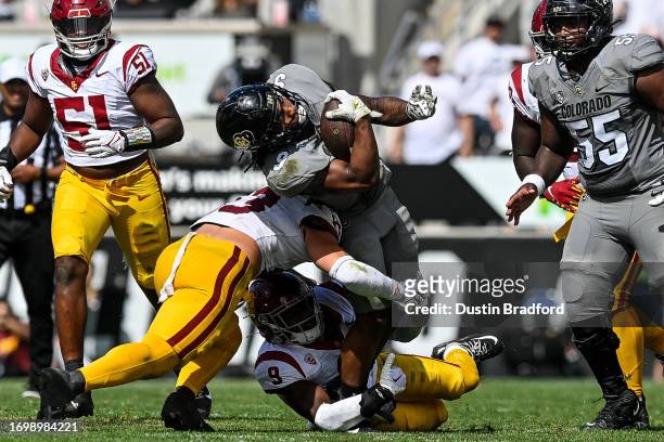 Tar'Varish Dawson of the Colorado Buffaloes is hit as he carries the ball in the fourth quarter against the USC Trojans at Folsom Field on September...