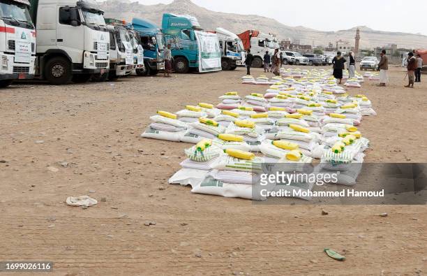 Food rations provided by the Zakat authority are displayed as others loaded on vans to be distributed to poor families on September 24 in Sana'a,...