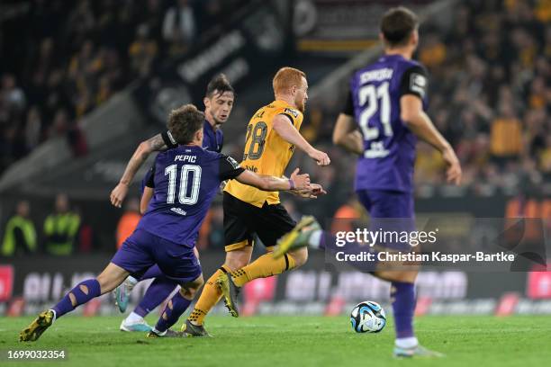 Paul Will of Dynamo Dresden is tackled by Mirnes Pepic of FC Erzgebirge Aue during the 3. Liga match between Dynamo Dresden and Erzgebirge Aue at...