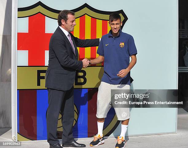 Barcelona President Sandro Rosell and Neymar shake hands as they pose for the media during the official presentation as a new player of the FC...