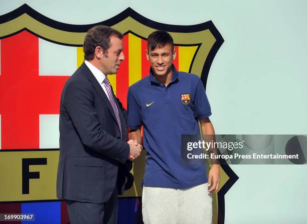 Barcelona President Sandro Rosell and Neymar shake hands as they pose for the media during the official presentation as a new player of the FC...