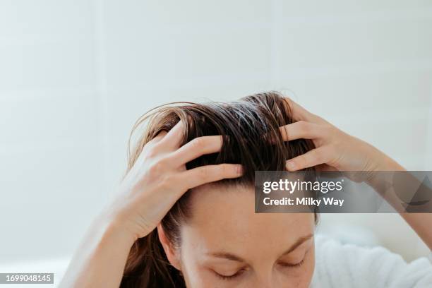 woman delicately doing massage of her scalp with cosmetic oil. - calvizie foto e immagini stock