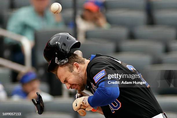 Pete Alonso of the New York Mets is hit by a pitch by Taijuan Walker of the Philadelphia Phillies that breaks the jaw guard of the helmet during the...