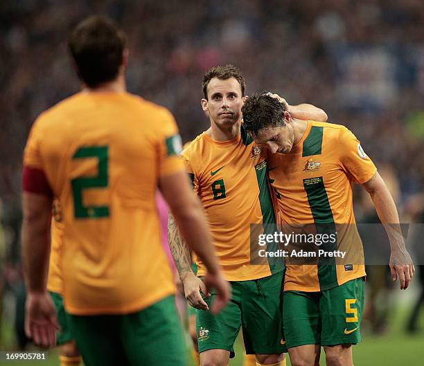 Luke Wilkshire and Mark Milligan of Australia are dejected after the FIFA World Cup qualifier match between Japan and Australia at Saitama Stadium on...