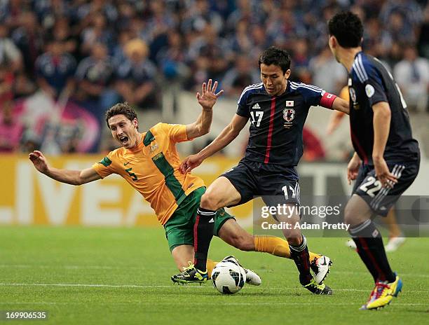 Mark Milligan of Australia is tackled by Makoto Hasebe of Japan during the FIFA World Cup qualifier match between Japan and Australia at Saitama...