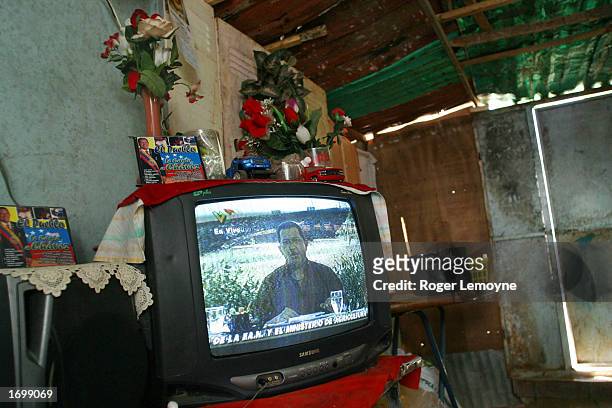 Television shows President Hugo Chavez giving a live address in a house in a slum December 21, 2002 on a hillside of the El Valle area in Caracas,...