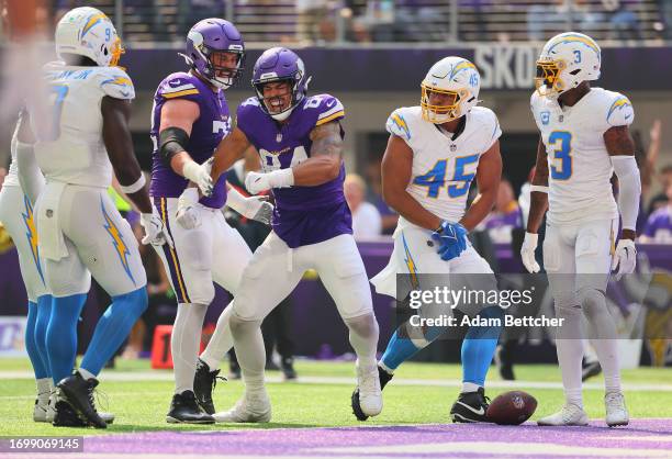 Ezra Cleveland of the Minnesota Vikings and Josh Oliver of the Minnesota Vikings celebrate Oliver's receiving touchdown while Tuli Tuipulotu of the...