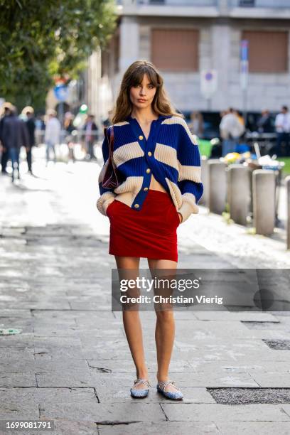 Mara Lafontan wears red velvet skirt, beige navy blue cardigan outside Bally during the Milan Fashion Week - Womenswear Spring/Summer 2024 on...