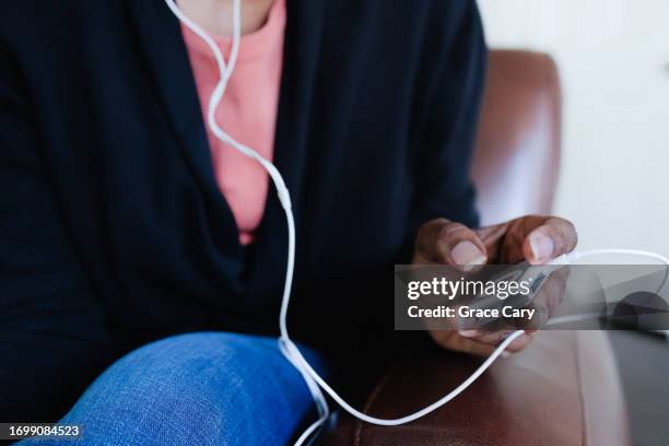 Woman Listens To Music On Mp3 Player With Wired Headphones High-Res Stock Photo