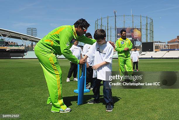 Nasir Jamshed of Pakistan gives some tips to a young player as they play a game of cricket with young fans from Curwen Primary School as members of...