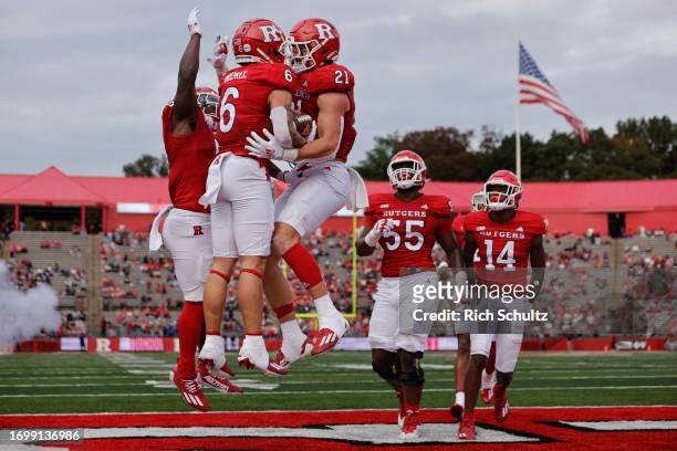 Christian Dremel of the Rutgers Scarlet Knights celebrates his touchdown catch with teammates Johnny Langan and Kyle Monangai against the Wagner...
