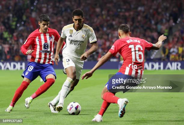Jude Bellingham of Real Madrid is challenged by Alvaro Morata and Nahuel Molina of Atletico Madrid during the LaLiga EA Sports match between Atletico...