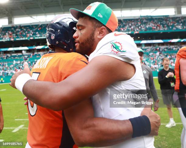 Russell Wilson of the Denver Broncos hugs Tua Tagovailoa of the Miami Dolphins after Miami's 70-20 win at Hard Rock Stadium on September 24, 2023 in...