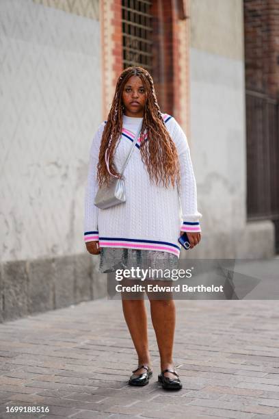 Guest wears a white oversize sweater with pink and navy blue borders, a silver Telfar crossbody bag, a silver sequined pleated skirt, black ballerina...