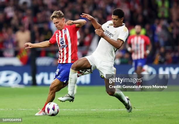 Marcos Llorente of Atletico Madrid is challenged by Jude Bellingham of Real Madrid during the LaLiga EA Sports match between Atletico Madrid and Real...