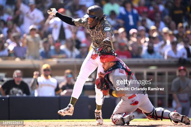 Fernando Tatis Jr. #23 of the San Diego Padres is tagged out at home plate by Ivan Herrera of the St. Louis Cardinals during the fourth inning at...