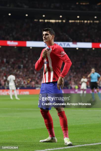 Alvaro Morata of Atletico de Madrid holds the badge on his t-shirt as he celebrates scoring their opening goal during the LaLiga EA Sports match...